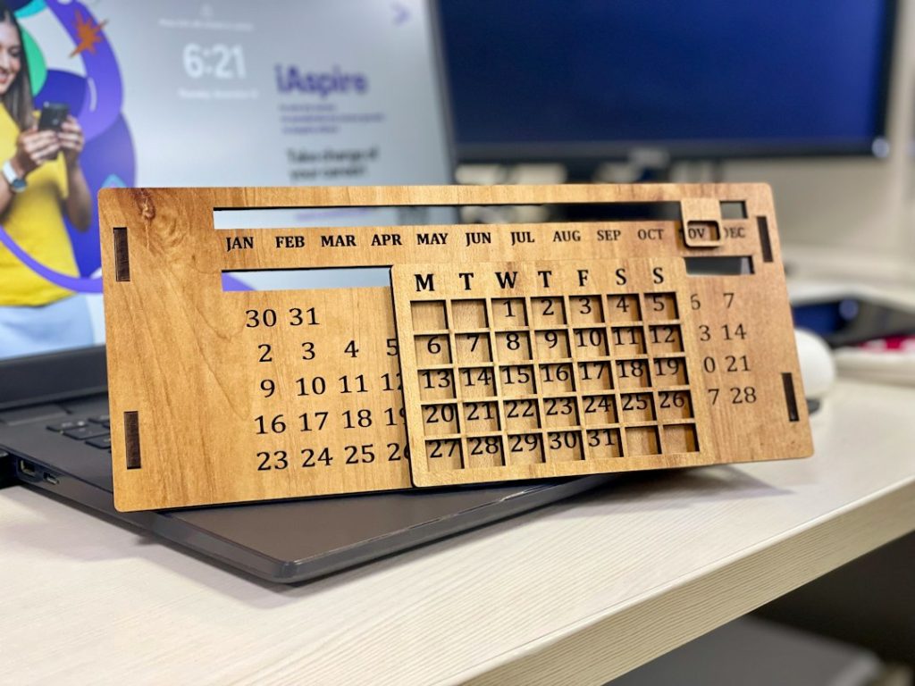 Calendrier de bureau en bois posé sur un ordinateur portable