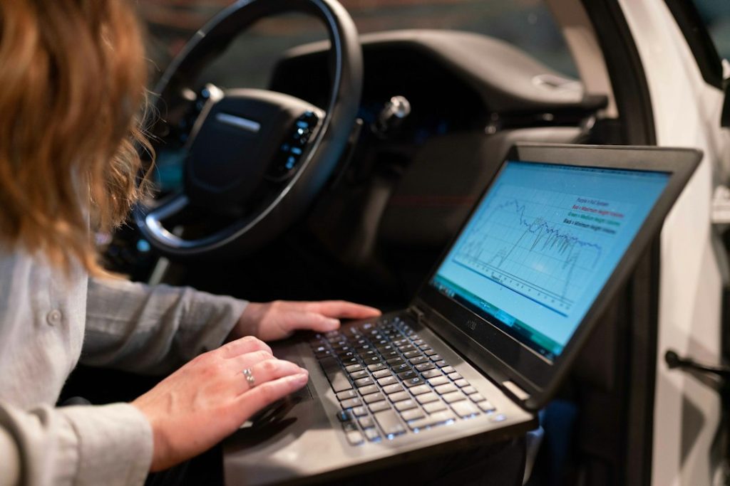 Personne utilisant un ordinateur portable dans l’habitacle d’une voiture