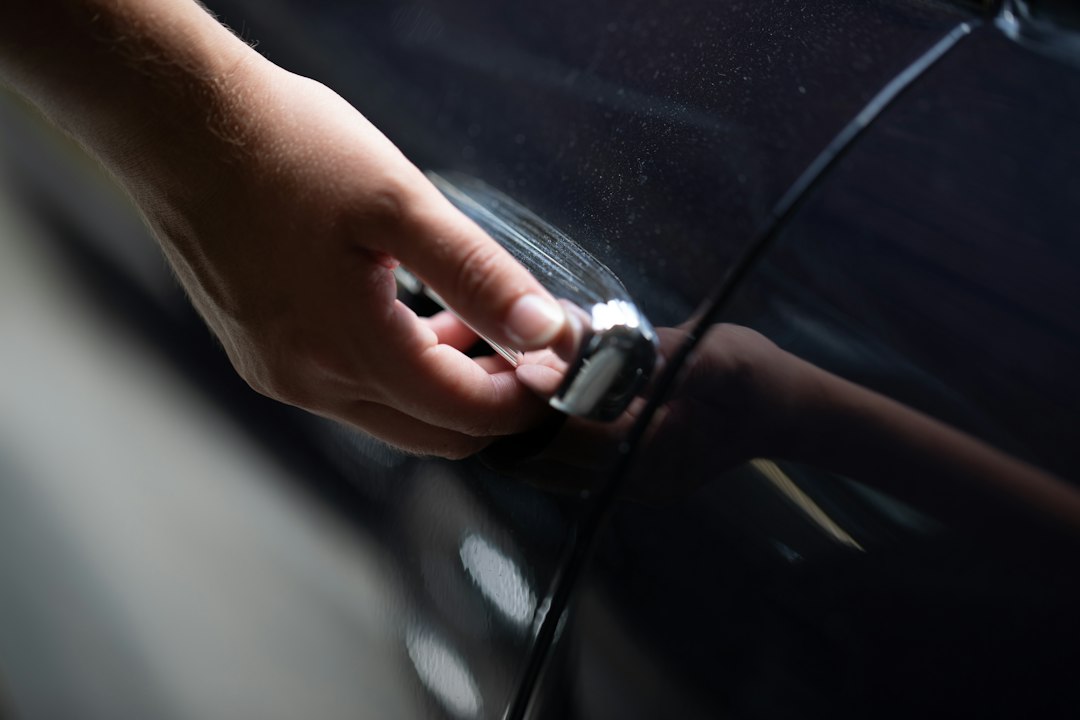 Main sur la poignée extérieure d’une portière de voiture