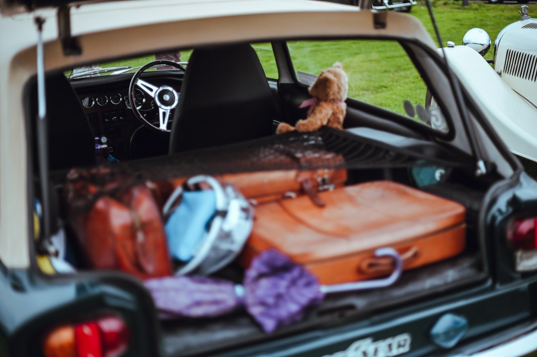 Coffre ouvert d’une voiture ancienne contenant des valises