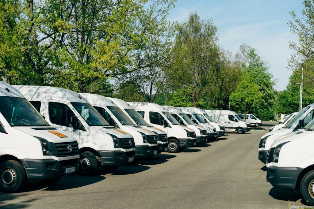 Plusieurs fourgons blancs stationnés sur un parking