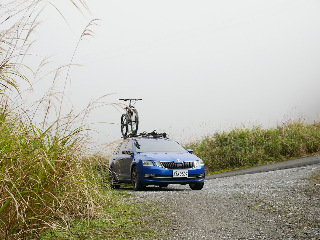 Voiture bleue équipée d’un vélo sur un porte-vélos de toit
